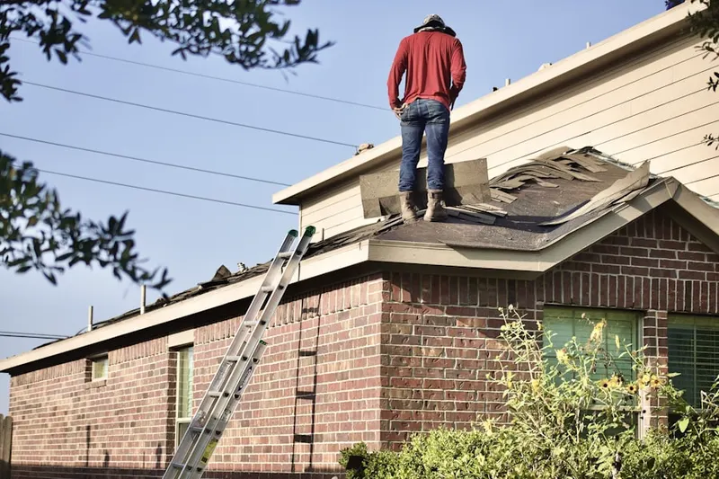 Professional roofer working on a residential roof in Drake